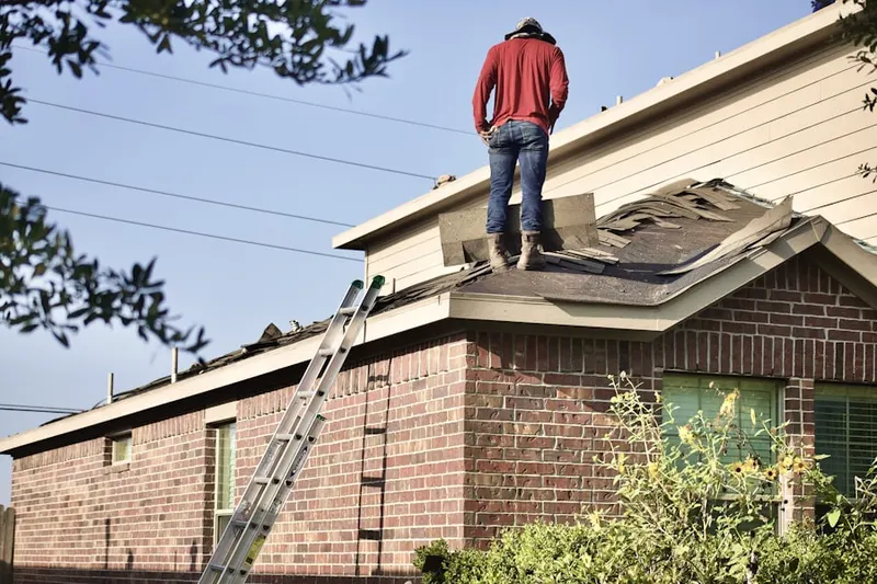 Professional roofer working on a residential roof in Normanda